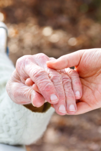 Elderly couples' hands touching.